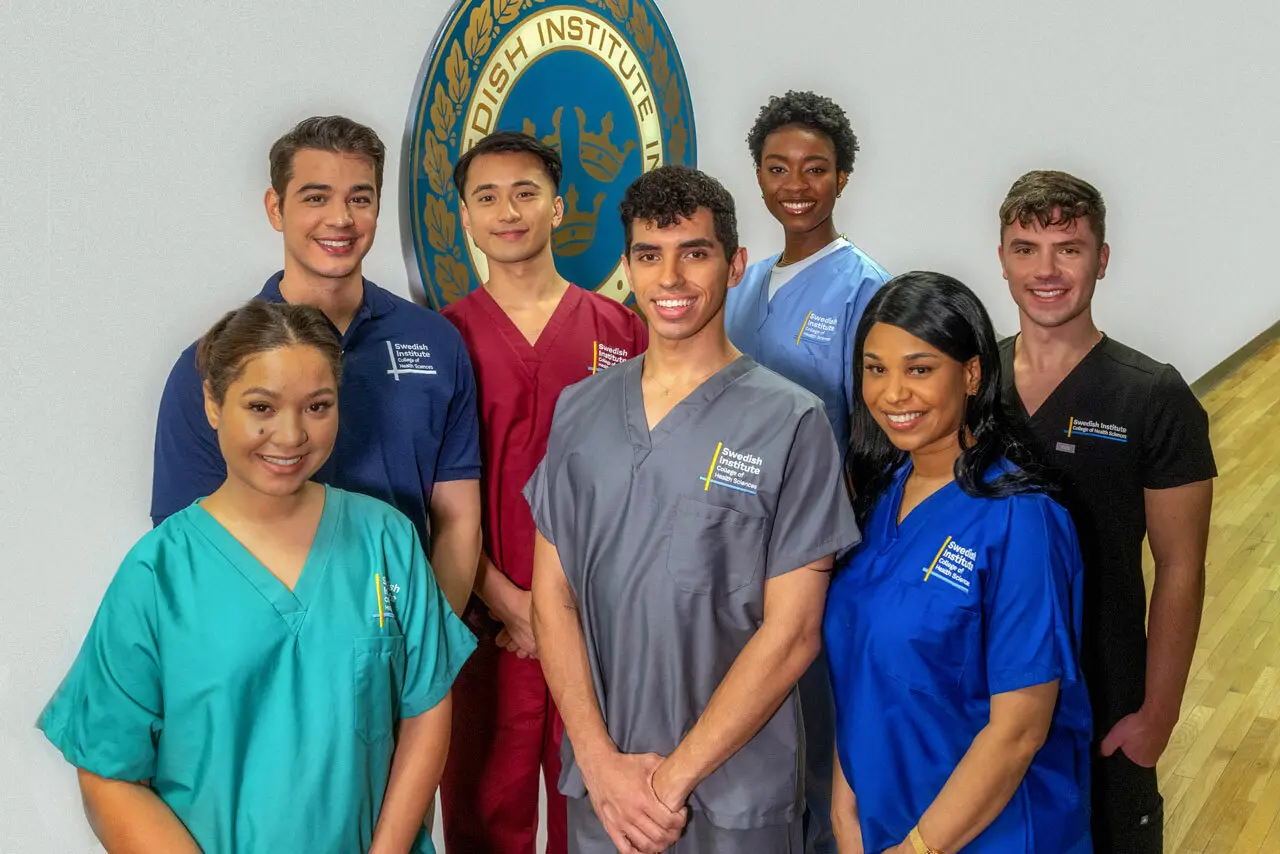 a group of Swedish Institute students standing in front of a wall with the school logo.