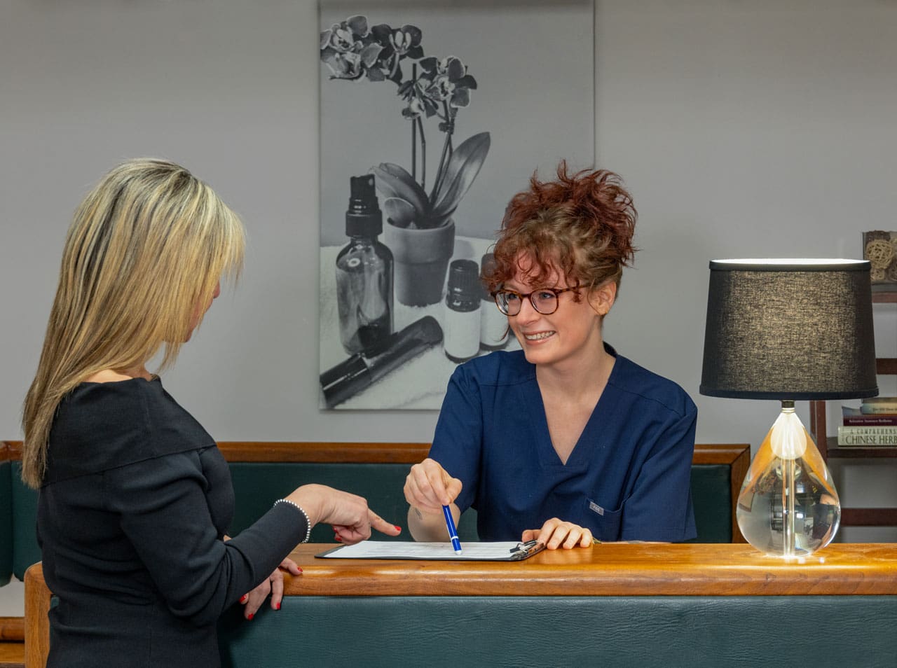client at the massage therapy clinic reception desk.