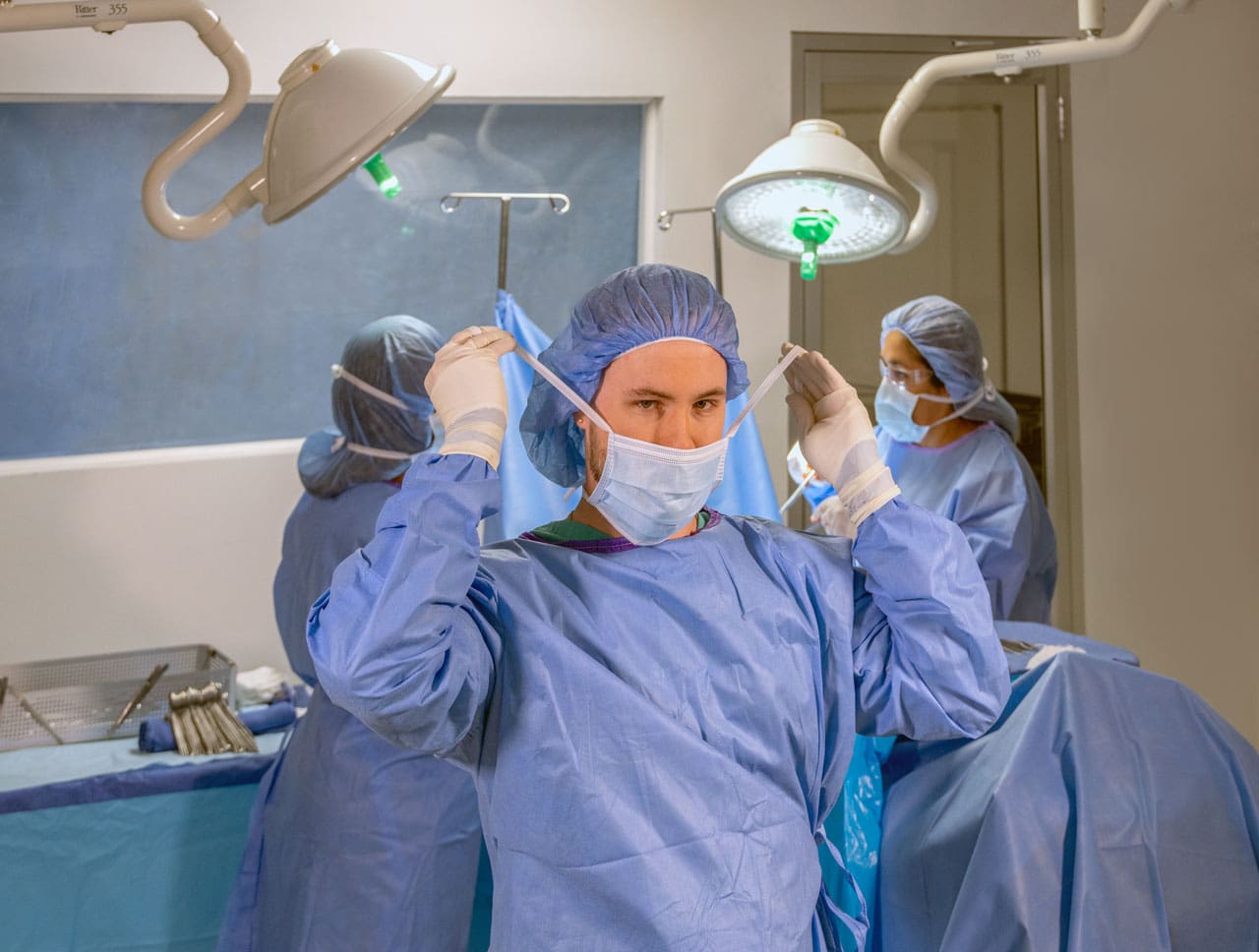 a surgical technologist wearing surgical gear preparing for surgery 